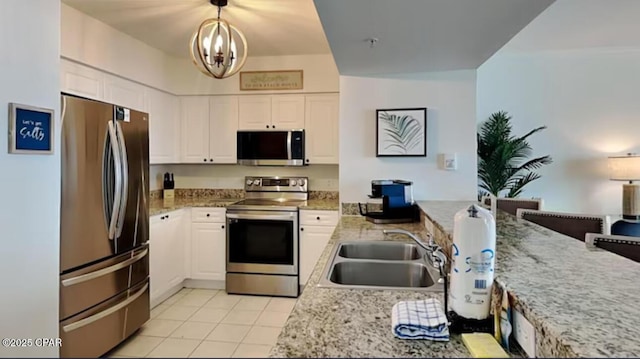 kitchen featuring a sink, decorative light fixtures, appliances with stainless steel finishes, and white cabinets