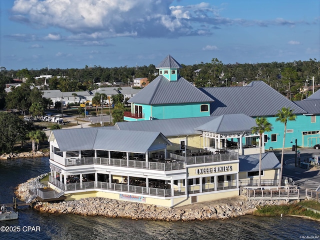 rear view of house featuring a water view and metal roof