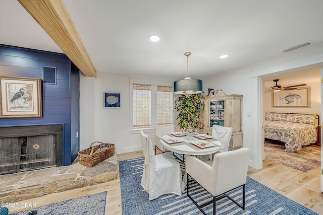 dining space with recessed lighting, visible vents, a fireplace, and wood finished floors