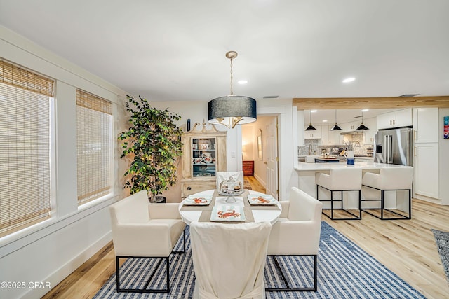 dining room featuring baseboards, light wood-type flooring, and recessed lighting