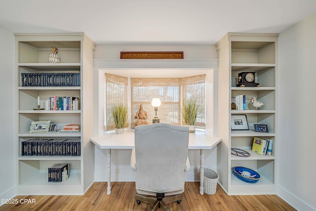 office space featuring built in shelves, baseboards, and wood finished floors