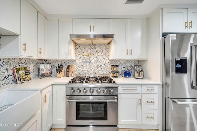 kitchen with white cabinetry, light countertops, appliances with stainless steel finishes, ventilation hood, and tasteful backsplash