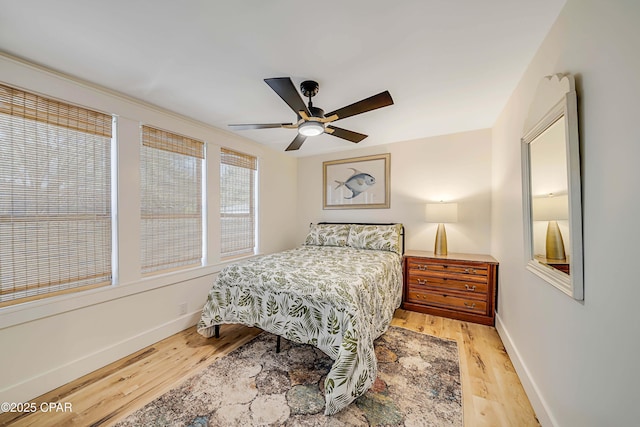 bedroom featuring ceiling fan, baseboards, and wood finished floors