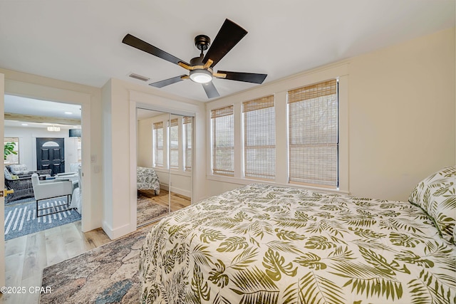 bedroom with visible vents, baseboards, ceiling fan, light wood-style floors, and a closet