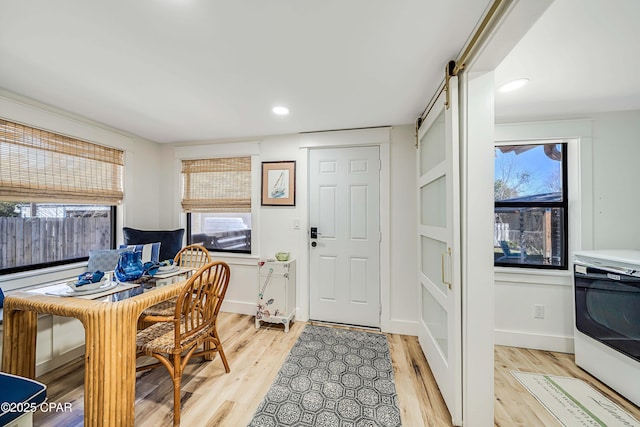 office area featuring light wood-style floors, a wealth of natural light, and a barn door