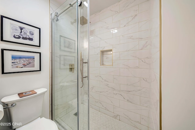 bathroom featuring toilet and a shower stall