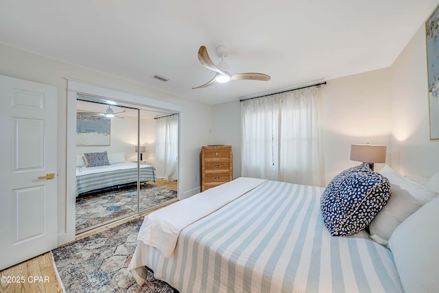 bedroom with visible vents, a closet, a ceiling fan, and wood finished floors