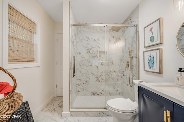 bathroom featuring marble finish floor, a marble finish shower, toilet, vanity, and baseboards