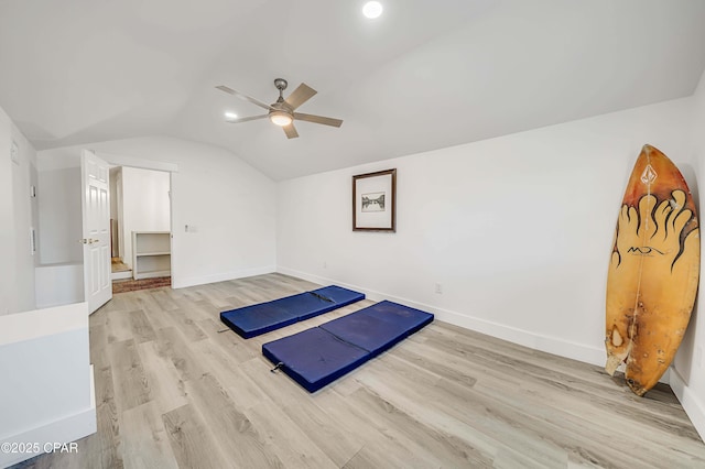 exercise area featuring lofted ceiling, ceiling fan, wood finished floors, and baseboards