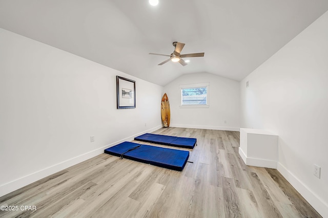 workout room with a ceiling fan, lofted ceiling, baseboards, and wood finished floors