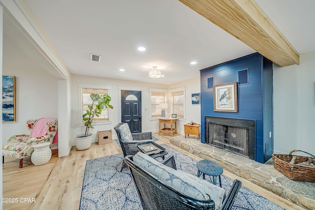 living room with recessed lighting, visible vents, a fireplace, and wood finished floors