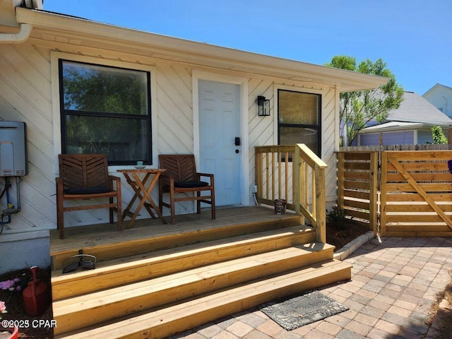 property entrance featuring a porch and fence