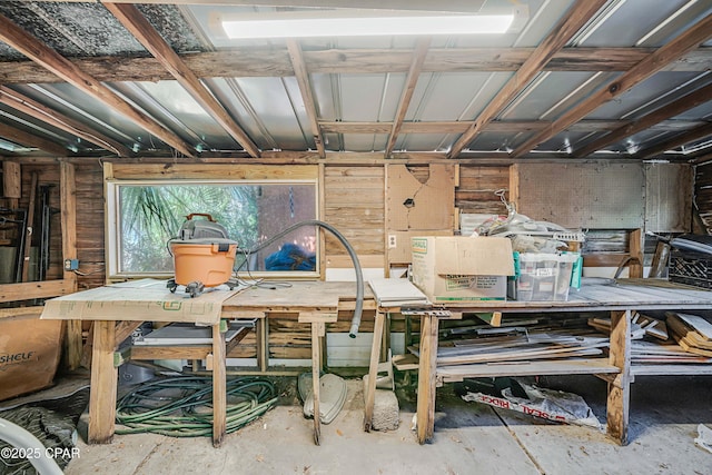 interior space featuring unfinished concrete flooring and a workshop area