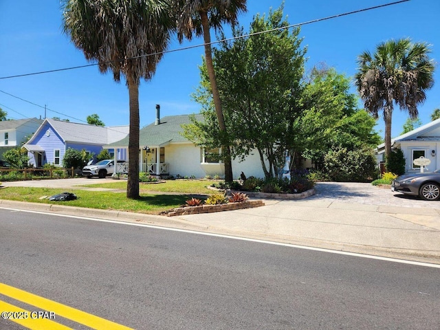 view of front facade featuring concrete driveway and a front yard