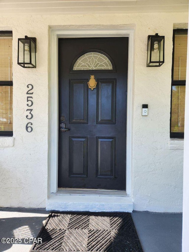 entrance to property featuring stucco siding