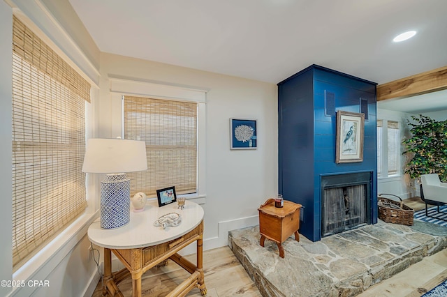 living area with light wood-style floors, a fireplace, and baseboards