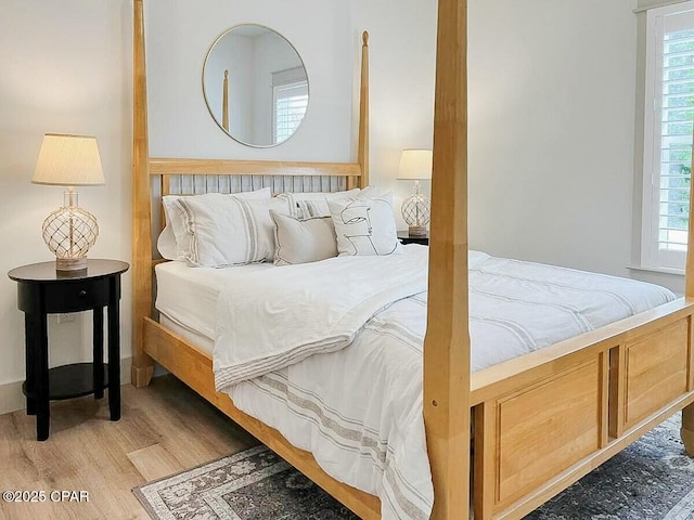 bedroom with multiple windows and wood finished floors