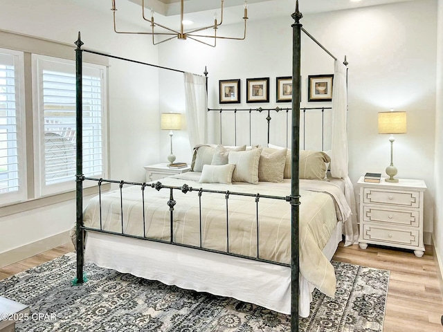 bedroom featuring baseboards and light wood finished floors