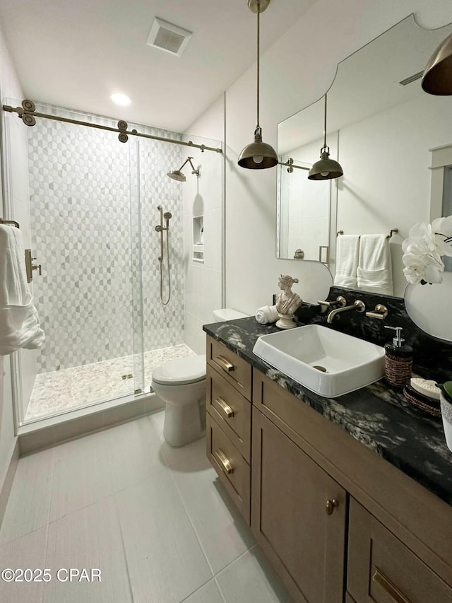 bathroom with vanity, visible vents, a stall shower, tile patterned floors, and toilet