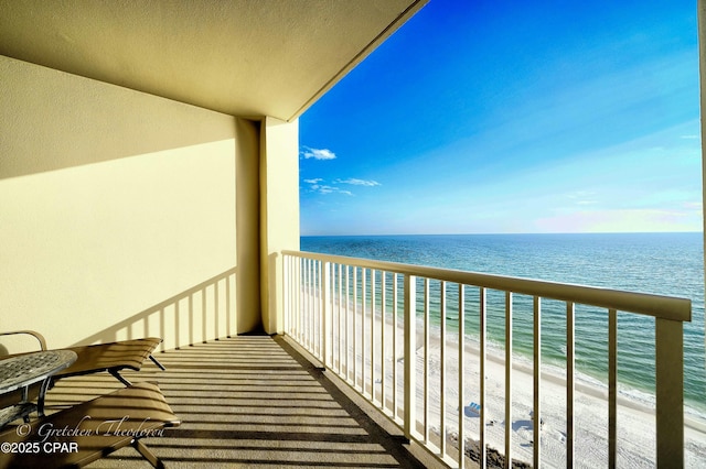 balcony featuring a water view and a view of the beach