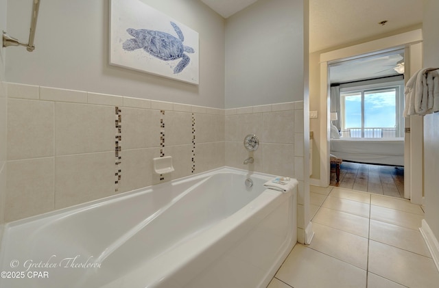 bathroom featuring tile patterned floors, a garden tub, baseboards, and ensuite bathroom