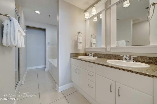 bathroom featuring tile patterned flooring, double vanity, a shower with shower door, and a sink