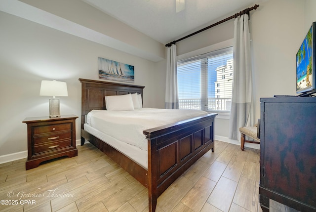 bedroom featuring a ceiling fan, baseboards, and light wood-type flooring