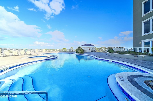 community pool with a patio and a community hot tub