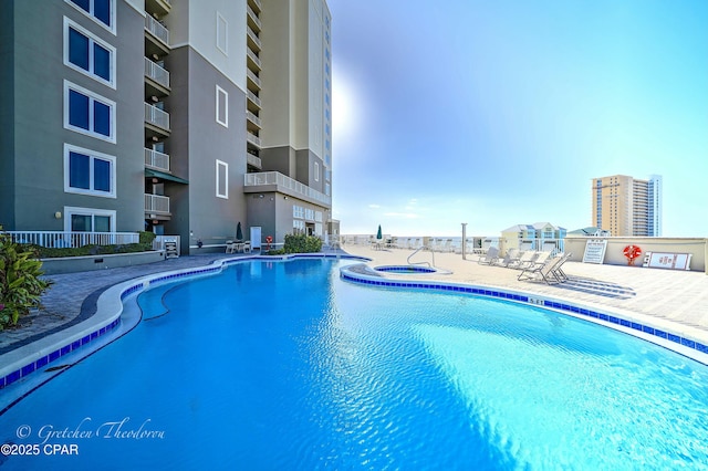 community pool with a community hot tub and a patio