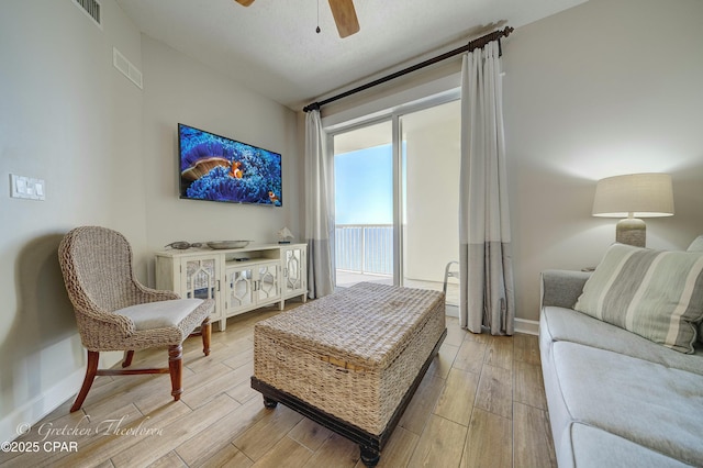 sitting room featuring a ceiling fan, wood finished floors, and visible vents