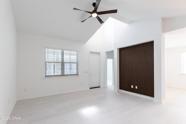 interior space with multiple windows, high vaulted ceiling, and wood finished floors