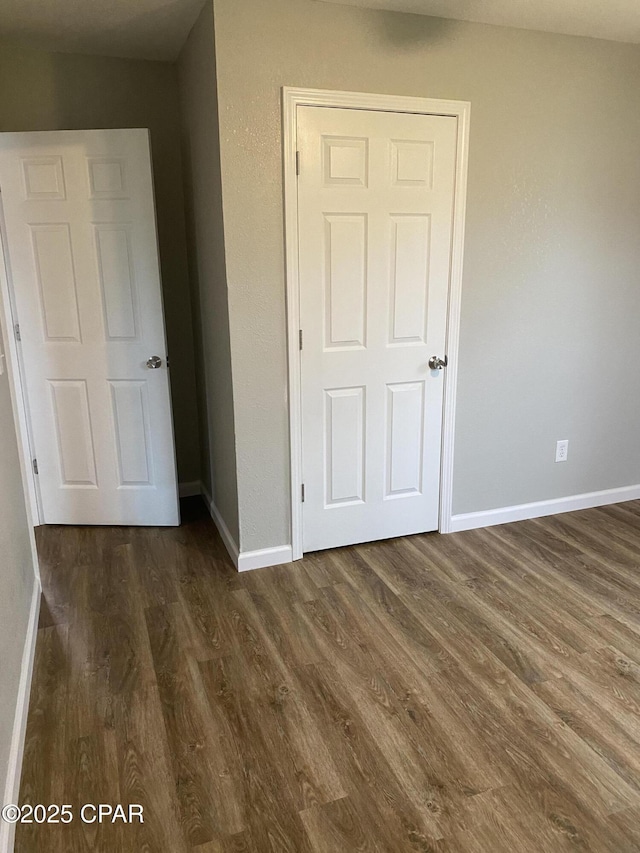 unfurnished bedroom with dark wood-style floors and baseboards