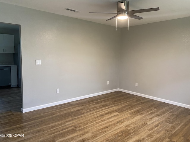 empty room featuring baseboards, visible vents, dark wood-style flooring, and ceiling fan