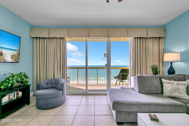 living area featuring light tile patterned floors and a water view