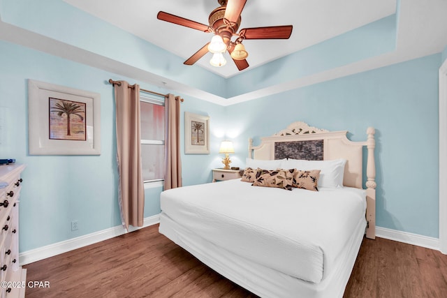 bedroom featuring ceiling fan, baseboards, and wood finished floors