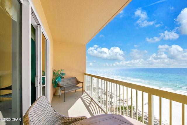 balcony with a water view and a beach view