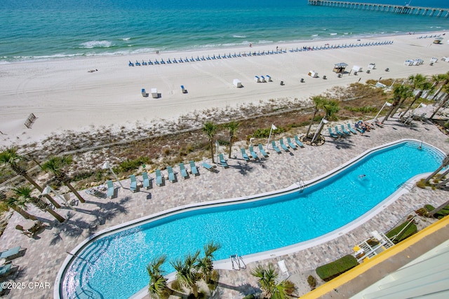 view of pool featuring a view of the beach and a water view