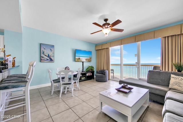 living room featuring light tile patterned flooring, baseboards, and ceiling fan