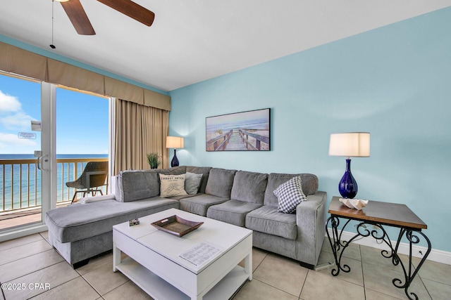 living area featuring light tile patterned flooring, baseboards, a water view, and ceiling fan