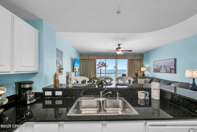 kitchen featuring a sink, open floor plan, white cabinetry, dishwashing machine, and ceiling fan