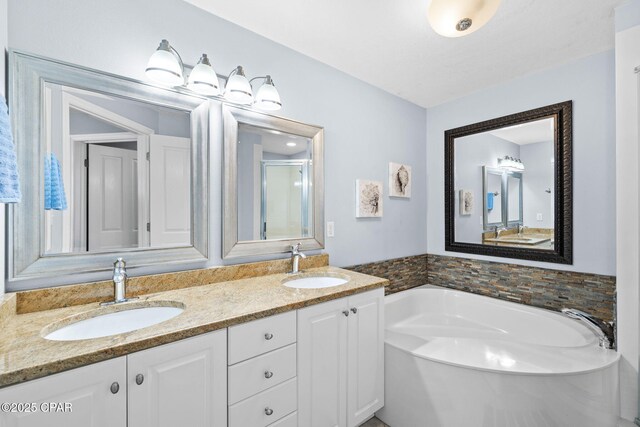 bathroom with a bath, double vanity, and a sink