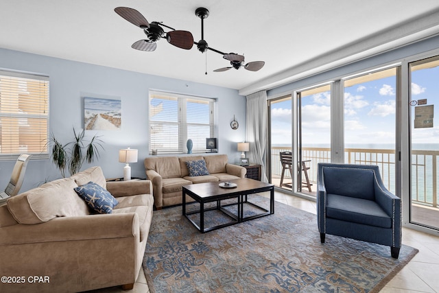 living area featuring tile patterned floors, a healthy amount of sunlight, and ceiling fan