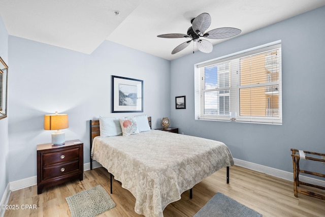 bedroom featuring a ceiling fan, baseboards, and wood finished floors