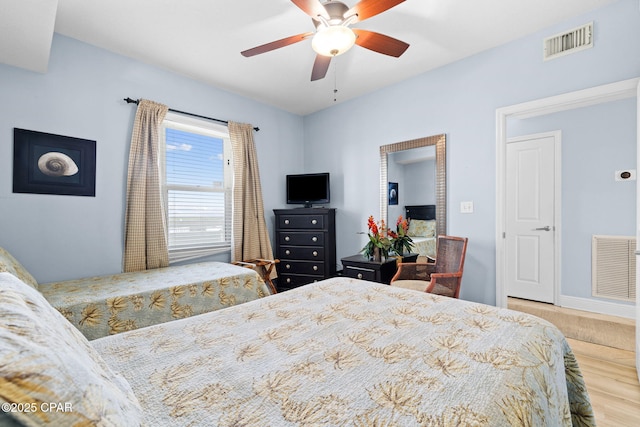 bedroom featuring wood finished floors, visible vents, and ceiling fan