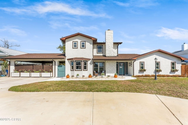 view of front of house with an attached carport, fence, a front yard, and a chimney