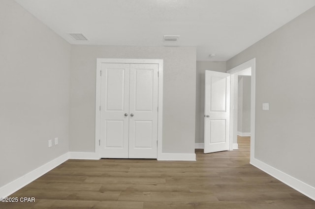 8470 Sun Point Dr, Panama City, FL 32404 - unfurnished bedroom with a closet and wood finished floors