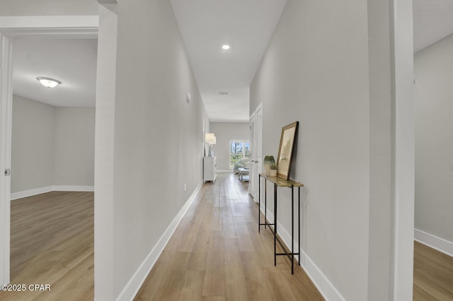 hallway with light wood-style floors and baseboards