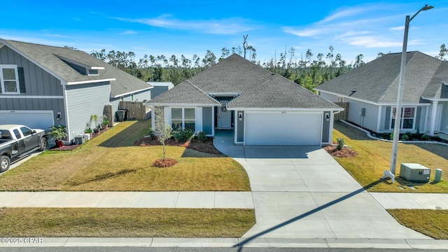 8470 Sun Point Dr, Panama City, FL 32404 - view of front facade featuring a garage, concrete driveway, a front lawn, and board and batten siding