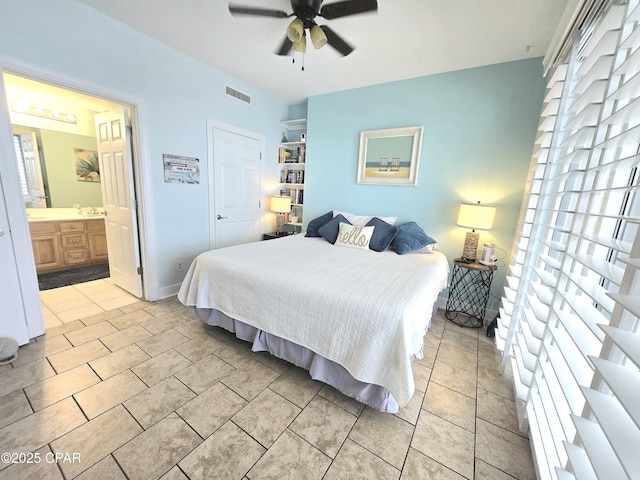 bedroom featuring visible vents, ceiling fan, light tile patterned flooring, ensuite bath, and a sink