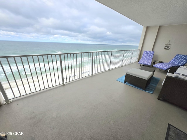 balcony with a water view and a view of the beach